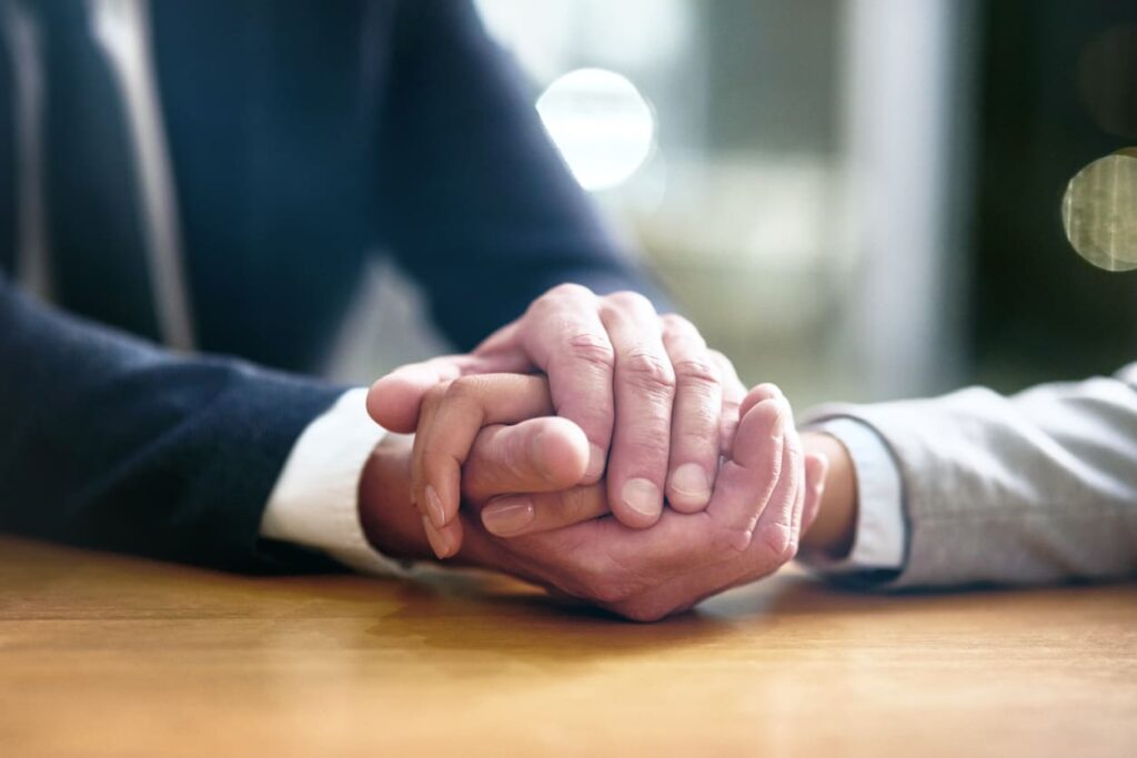 attorney holding client hands