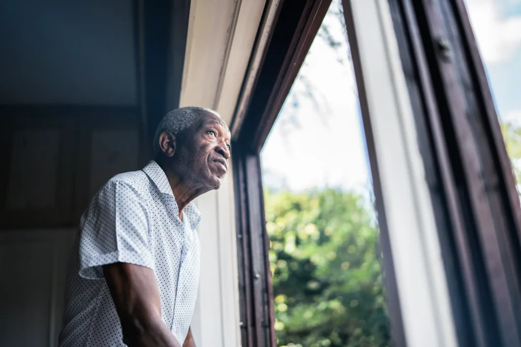 elderly man looking out window