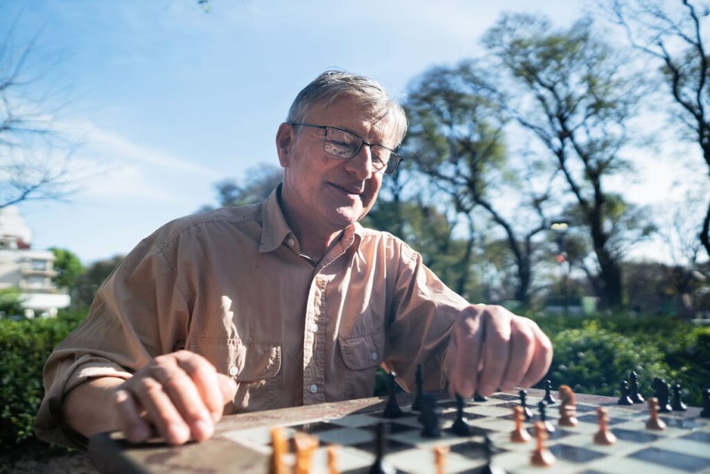 senior man playing chess outdoors