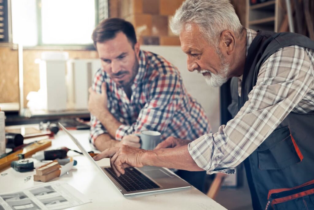 two people consulting at laptop